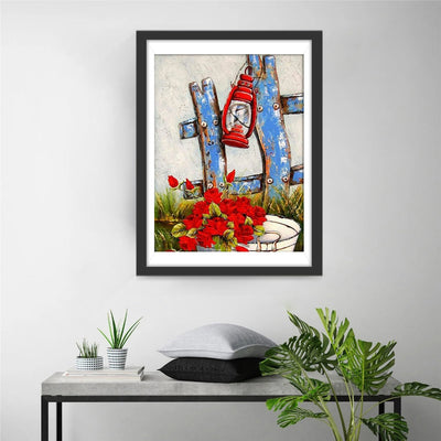 Blauer Zaun, rote Kerosinlampe und rote Blumen Diamond Painting